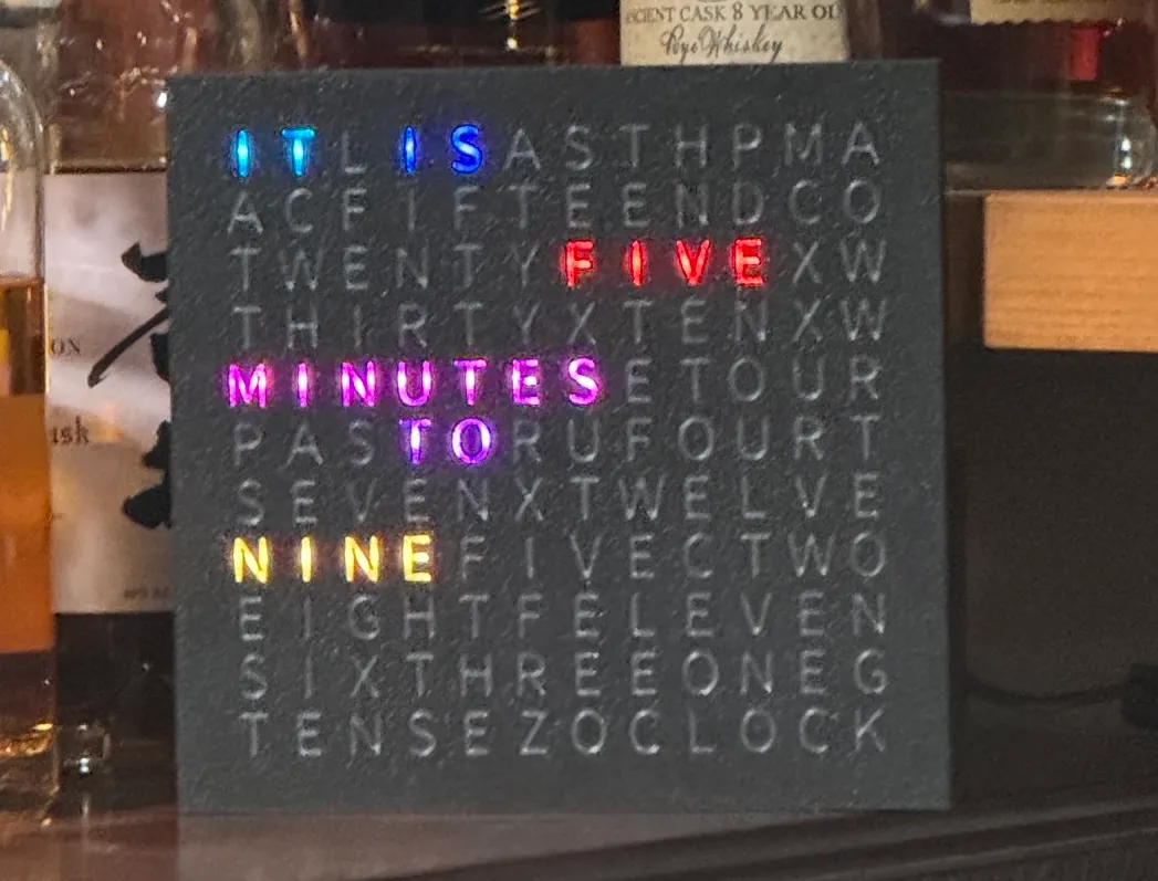 The v1.0 build — black frame with clear letters. Clear gives each LED a hot-spot; print the letters in white