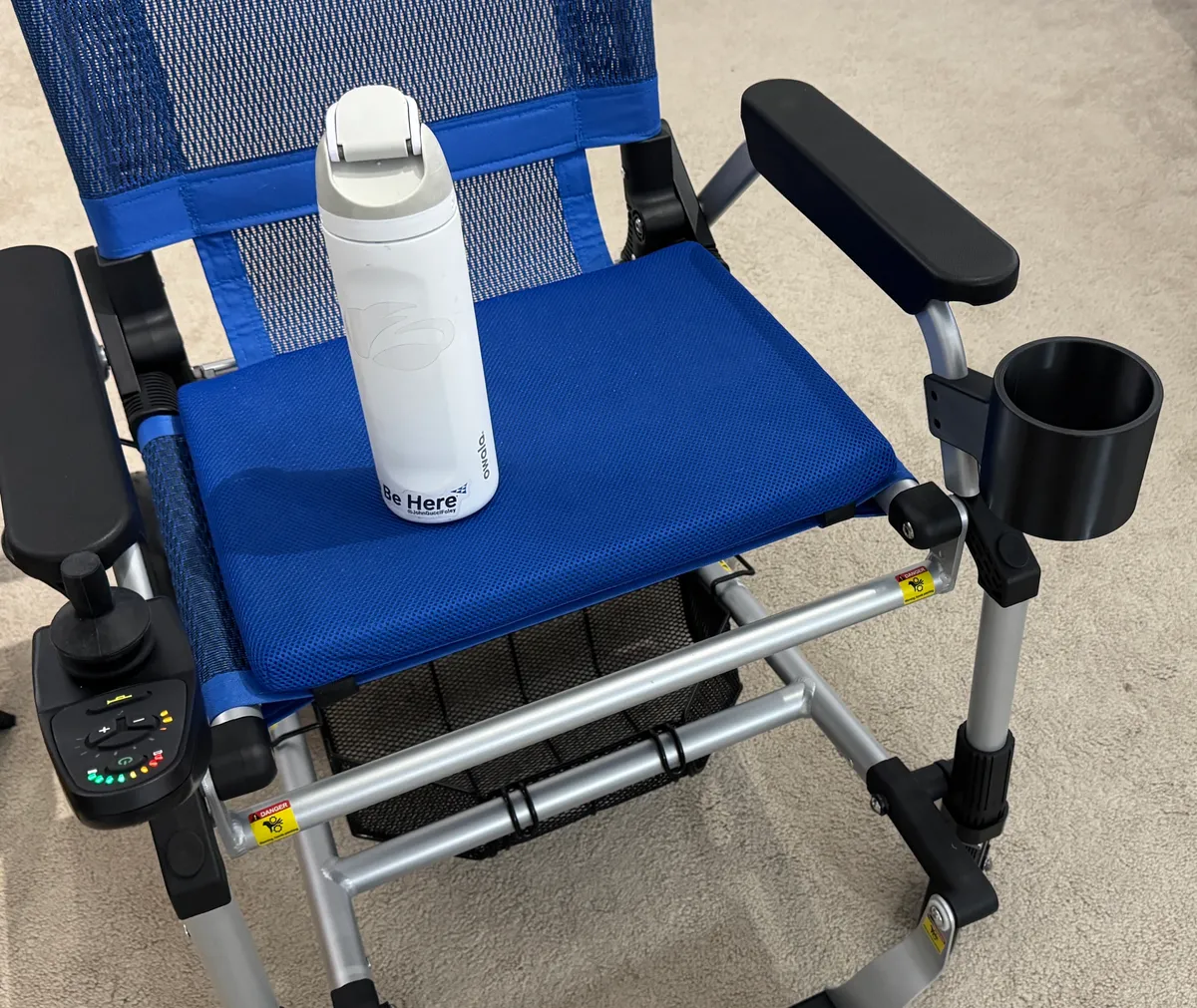 Mounted high on the arm — out of the way of legs, wheels, and doorframes